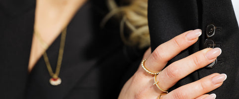 Close-up of Loretana 14K gold rings stack on model hand with bracelet, sizing reference for hoops and rings. Hallmarked 925 silver core, Kaunas.