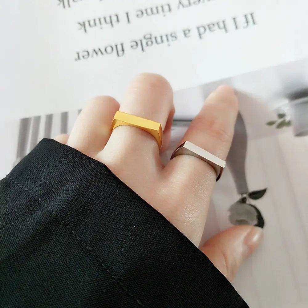 Tuva modeļa rokas attēls, kurā redzams personalizēts 925 sudraba gravējams taisnstūra gredzens.