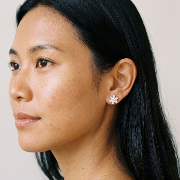 Loretana 925 silver flower stud earring with six petals and clear CZ stones, worn on the ear